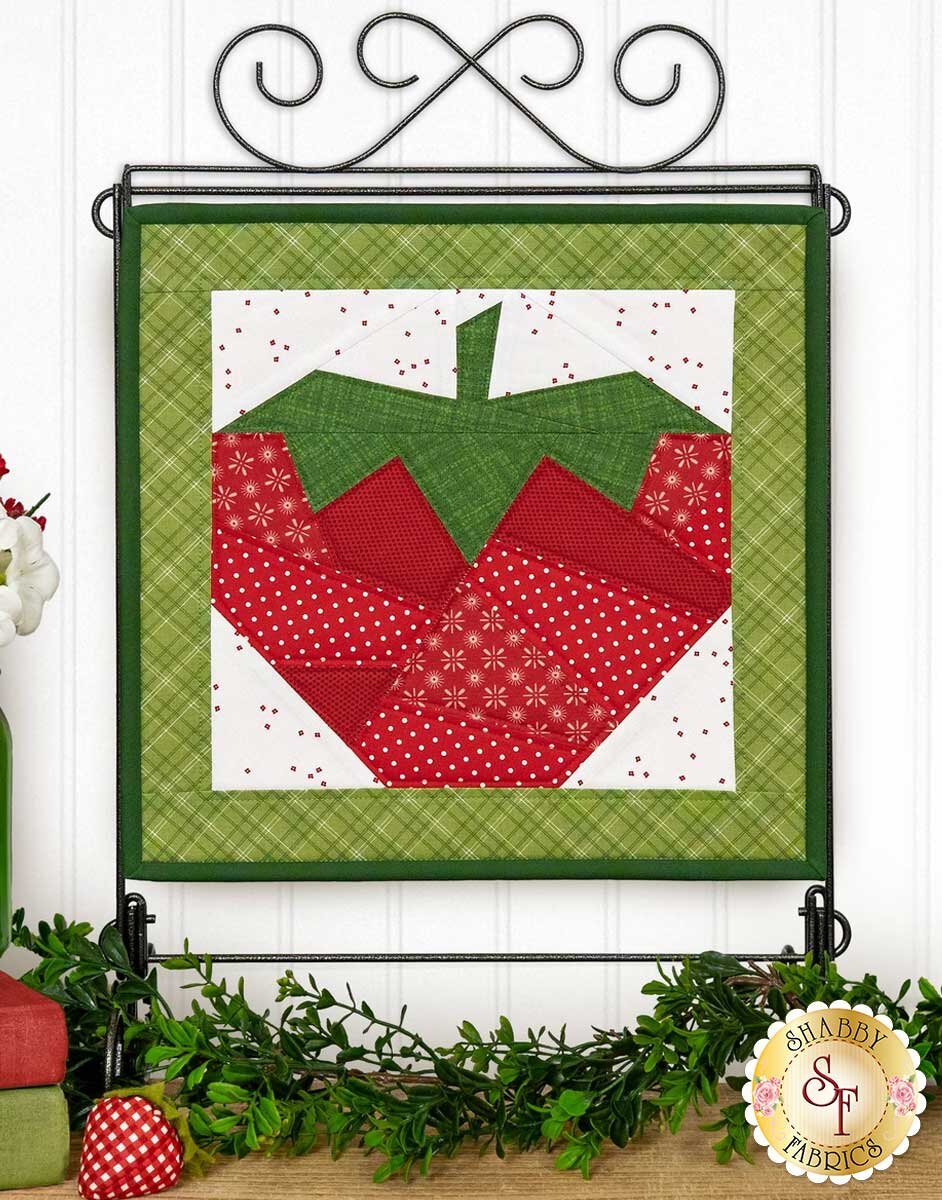 fpp_series_4_june_hero.jpg The finished June foundation paper pieced strawberry block displayed on a stand.