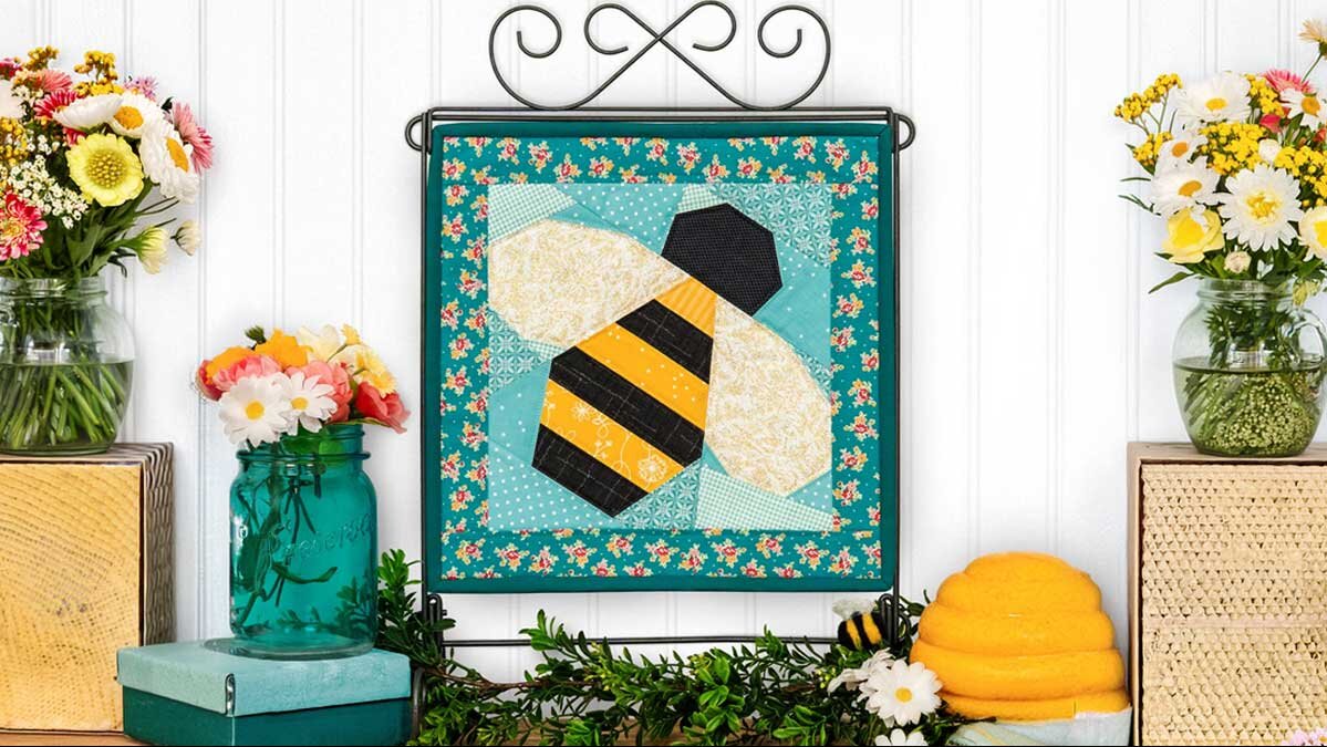fpp_august_4_staged_completed_block.jpg The finished August foundation paper pieced bee block, its wings stitched in glittering fairy frost fabric.