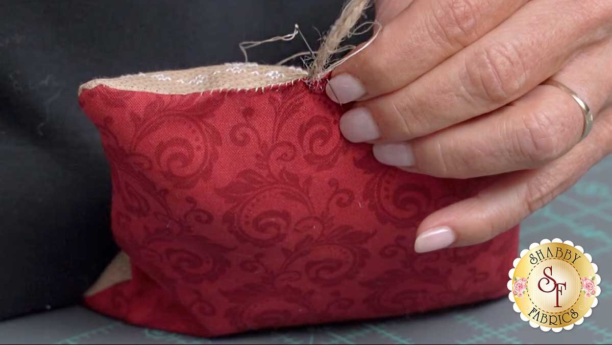 farmhouse_christmas_ornaments_stitching_opening.jpg The jute hanger held in place at the midpoint of the opening while being stitched through like fabric.