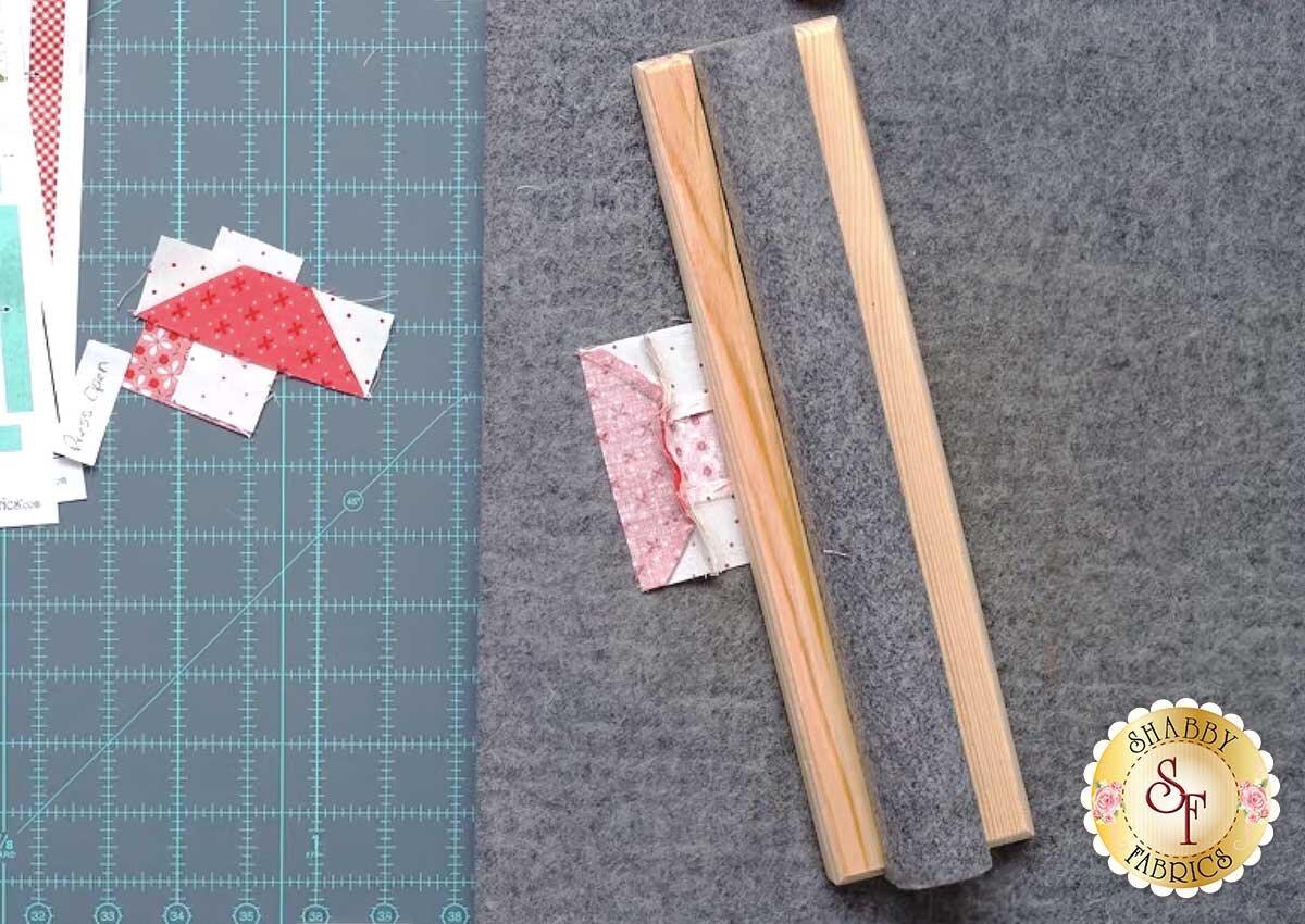 sew_cute_runner_september_presser_bar.jpg A wooden clapper resting on a freshly pressed seam on a wool pressing mat.